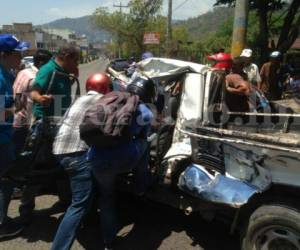 Varios hondureños ayudaron a sacar al hombre de su vehículo para llevarlo al Hospital Escuela Universitario. Foto Estalin Irías/El Heraldo.