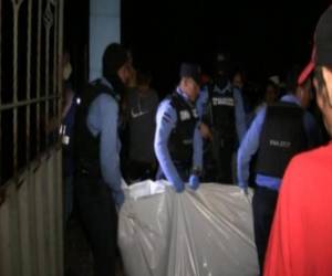Elementos de la Policía Nacional de Honduras cargan el cuerpo de unas de las personas fallecidas.