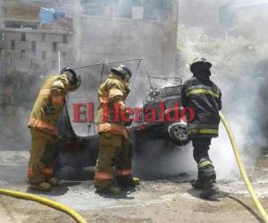 Miembros del Cuerpo de Bomberos de Honduras llegaron a la zona para apagar las llamas que consumian la mototaxi. Foto: Estalin Irías/EL HERALDO.