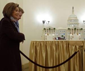 La presidenta de la Cámara de Representantes, Nancy Pelosi, pasa frente a un modelo de pan de jengibre del Capitolio de los Estados Unidos cuando llega al capitolio junto a su Secretario de Prensa, Drew Hammill. Foto: Agencia AFP.