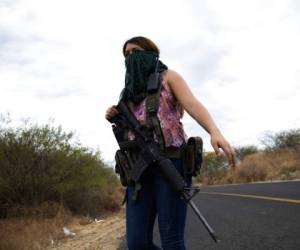 Una mujer armada vigila las afueras de El Terrero, en el estado de Michoacán, México. Foto AP