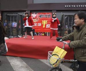 Esta foto muestra a vendedores de una tienda con trajes de Papa Noel bailando para atraer clientes, en Zhangjiakou, en la provincia de Hebei, en el norte de China. Foto: AP
