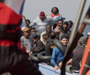 Migrantes reaccionan al equipo de SOS Mediterranee durante una operación de rescate a unas 53 millas náuticas (98 kilómetros) de la costa de Libia en el Mar Mediterráneo. Foto AP.