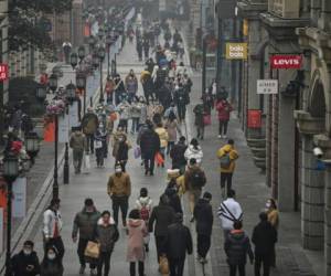 La gente camina por una calle peatonal en Wuhan, provincia de Hubei, en el centro de China, el 23 de enero de 2021, un año después de que la ciudad se bloqueara para frenar la propagación del coronavirus covid-19. Foto: AFP