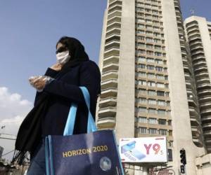 Una mujer con mascarilla cruza la calle en el norte de Teherán, Irán. Foto: AP.