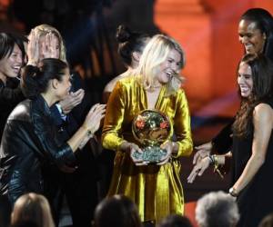 Olympique Lyonnais' Norwegian forward Ada Hegerberg (C) celebrates with her teammates after receiving the 2018 FIFA Women's Ballon d'Or award for best player of the year during the 2018 FIFA Ballon d'Or award ceremony at the Grand Palais in Paris on December 3, 2018. - The winner of the 2018 Ballon d'Or will be revealed at a glittering ceremony in Paris on December 3 evening, with Croatia's Luka Modric and a host of French World Cup winners all hoping to finally end the 10-year duopoly of Cristiano Ronaldo and Lionel Messi. (Photo by FRANCK FIFE / AFP)