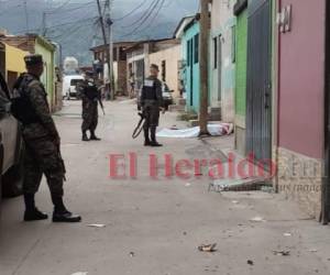 El cadáver de Medica quedó al lado de un poste del tendido eléctrico y fue cubierto con una sábana por los vecinos. Foto: Estalin Irías / EL HERALDO.