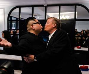 El imitador del líder norcoreano Kim Jong Un, Howard X y el imitador del presidente de los Estados Unidos Donald Trump, Russel White, posan en un hotel antes de ser escoltados por las autoridades vietnamitas al aeropuerto, en Hanoi.(Foto: AFP)