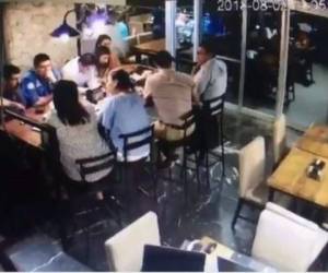 En las imágenes se observa cómo la joven que roba la billetera se la pasa a otra para poder salir del restaurante.