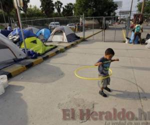 En esta fotografía del 30 de abril de 2019, William Linares, un niño hondureño de 5 años, juega en un campamento donde vive cerca del puente internacional en Matamoros, México. (AP Foto/Eric Gay)