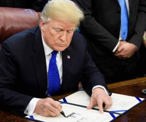 El presidente de los Estados Unidos, Donald Trump, firma el H.R. 390, un proyecto de ley que activa el apoyo a los cristianos y los yazidis como objetivo del ISIS. en la Oficina Oval de la Casa Blanca el 11 de diciembre de 2018 en Washington, DC. / AFP / Brendan Smialowski.