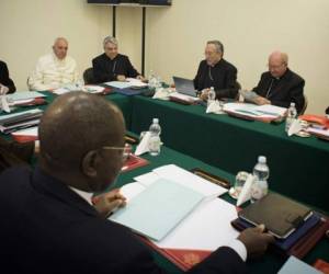En la imagen se puede observar a Rodríguez con una computadora portatil mientras ocupa la atención de los otros obispos.