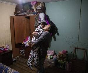 José Collantes abraza a su hija de cinco años Kehity mientras la acuesta a dormir en su casa. Foto AP