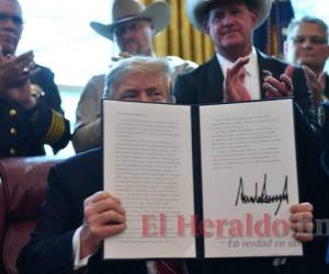 Donald Trump muestra la firma del veto presidencial, que tumba temporalmente la anulación que hizo el Congreso y el Senado a su plan para financiar el muro fronterizo con fondos de una declaración de emergencia. Foto: AP.