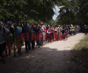 Un helicóptero sobrevoló a baja altura mientras los migrantes vadeaban las turbias aguas del río Suchiate en grandes grupos, aparentemente intentando desalentarlos con el viento de las hélices.