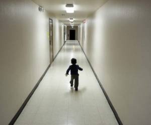 ARCHIVO - En esta fotografía de archivo del 11 de diciembre de 2018, un niño centroamericano cuyos padres le solicitan asilo en Estados Unidos corre por un pasillo tras llegar a un albergue en San Diego. (AP Foto/Gregory Bull, archivo)