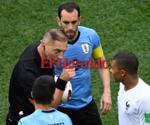 El árbitro argentino Nestor Pitana disciplina al delantero francés Kylian Mbappe durante el partido de cuartos de final de la Copa del Mundo Rusia 2018 entre Uruguay y Francia en el Estadio Nizhny Novgorod .