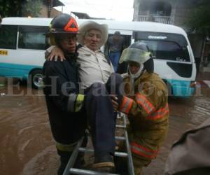 Bastó una hora de intensa lluvia para provocar caos en la populosa colonia Kennedy. Un anciano fue cargado por miembros del Cuerpo de Bomberos, pues las calles estaban anegadas de agua. Foto Jimmy Argueta/EL HERALDO