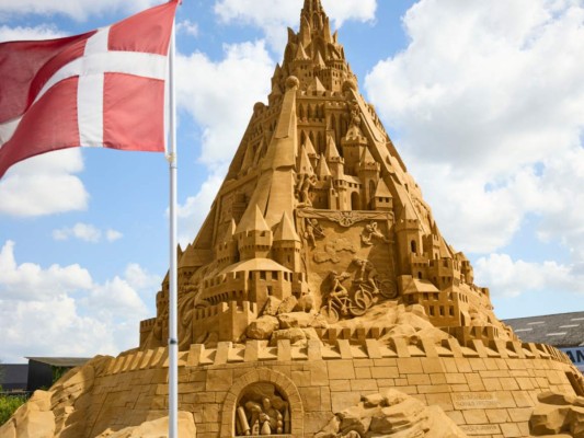 En la pequeña ciudad costera de Blokhus en Dinamarca, se completó el castillo de arena más alto del mundo, que pesa casi 5.000 toneladas y se eleva a más de 20 metros de altura, dijo su diseñador Wilfred Stijger el 7 de julio de 2021.