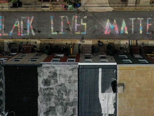 En una imagen aérea de un avión no tripulado, se ve una pintura mural de tiza 'Black Lives Matter' en la cuadra 300 de South Madeira Street el 16 de junio de 2020 en Baltimore, Maryland. Black Lives Matter se ha convertido tanto en un tema vocal como visual, ya que las protestas han continuado en todo el mundo tras los asesinatos policiales de George Floyd en Minneapolis. Foto: Agencia AFP.