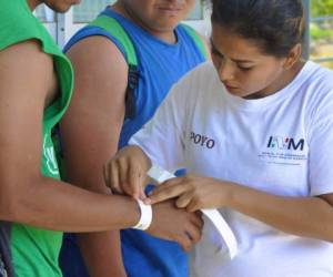 Las autoridades mexicanas entregaron pulseras para recibir las tarjetas humanitarias. Foto cortesía Twitter @INAMI_mx