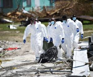 En Marsh Harbour se veía a trabajadores de la morgue buscar cadáveres y cargarlos en camiones en bolsas verdes. Foto: AFP.