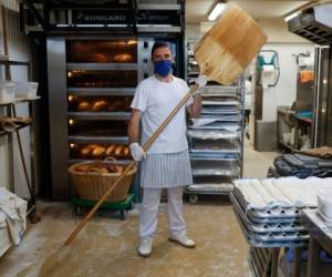 Spanish baker Antoni Valls, 43, poses with a peel at the Turris bakery in Barcelona on April 11, 2020, during a national lockdown to prevent the spread of the COVID-19 disease. - Spain will begin handing out masks at metro and train stations on April 13, 2020 as some companies will re-open after a two-week 'hibernation' period, the health minister said. On March 30, Spain toughened its nationwide lockdown, halting all non-essential activities until after Easter as it sought to further curb the spread of the virus. (Photo by PAU BARRENA / AFP)