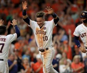 Los jugadores de los Astros de Houston Yuli Gurriel #10 celebra con José Altuve #27 y Carlos Correa #1.