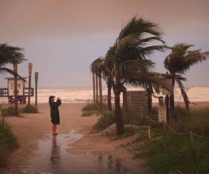 Una mujer toma una foto cuando los efectos del huracán Dorian comienzan a sentirse en Cocoa Beach, Florida. Foto: Agencia AFP.