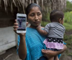 Claudia Maquin, la mamá de la niña, muestra una fotografía de su pequeña mientras sostiene al menor de sus hijos. Foto: AP