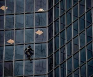 Robert, conocido mundialmente por escalar edificios emblemáticos sin cuerdas, y generalmente sin permiso, escaló en 52 minutos el edificio de la compañía Total. Foto: Agencia AFP.