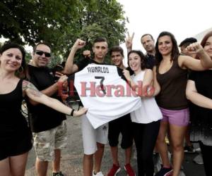 Aficionados celebran con una camiseta la llegada de Cristiano Ronaldo a la Juventus. Foto:AFP