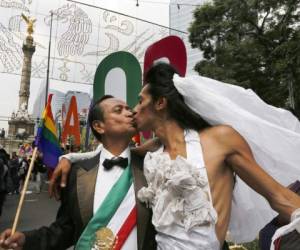 Dos manifestantes vestidos como novio y novia marchan contra la homofobia en Ciudad de México. Foto: AP.