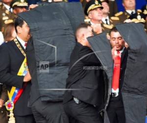 En esta foto publicada por la Agencia de Noticias Xinhua de China, el personal de seguridad rodea al presidente de Venezuela, Nicolás Maduro, al principio, durante un incidente como discurso en Caracas, Venezuela, el sábado 4 de agosto de 2018. Agencia AFP.