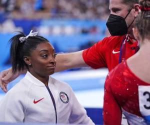 El técnico Laurent Landi consuela a Simone Biles tras su retiro de la competencia por equipos en la gimnasia olímpica el 27 de julio del 2021 en Tokio.