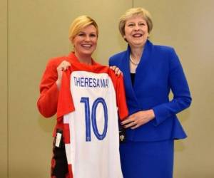 Kolinda, quien ha acaparado la atención por sus sexys fotos en traje de baño, le entrega una camiseta de la Selección de Croacia a la británica Theresa May, cuando ambos países están a punto de enfrentarse en Rusia 2018. (Foto: Twitter)
