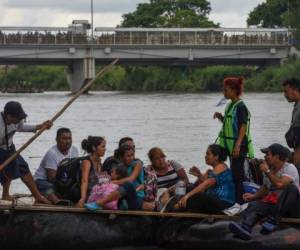 Los migrantes hondureños cruzan el río Suchiate, frontera natural entre Guatemala y México, en una balsa improvisada, en Ciudad Tecún, Uman. (Foto: AFP)