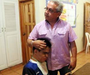 Javier López mientras abraza a su hijo Javier Arístides, de 28 años de edad, a quien considera como el pequeño de la casa. Foto: Jimmy Argueta: El Heraldo