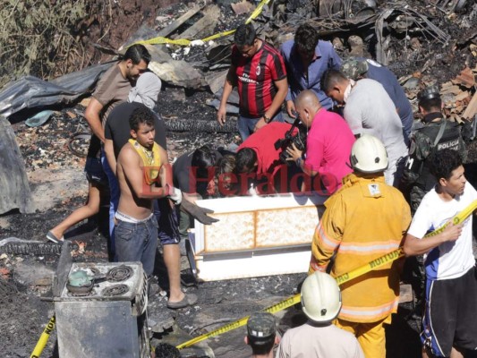 Los familiares irrumpieron la escena para levantar el cadáver y sacarlo del lugar. Foto: Estalin Irías/EL HERALDO.