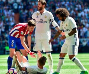 Atletico Madrid's midfielder Saul Niguez (L) helps Real Madrid's German midfielder Toni Kroos (C) beside Real Madrid's defender Sergio Ramos (C) and Real Madrid's Brazilian defender Marcelo (R) during the Spanish league football match Real Madrid CF vs Club Atletico de Madrid at the Santiago Bernabeu stadium in Madrid on April, 8, 2017. / AFP PHOTO / GERARD JULIEN