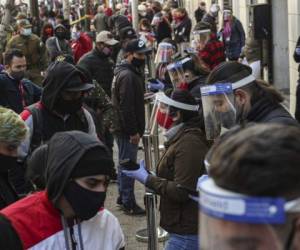 Empleados del gobierno usando mascarillas y caretas para protegerse del nuevo coronavirus ayudan a que la gente procese su retiro de un porcentaje de sus fondos de ahorro para el retiro en Santiago de Chile el jueves 30 de julio de 2020. (AP Foto/Esteban Felix)