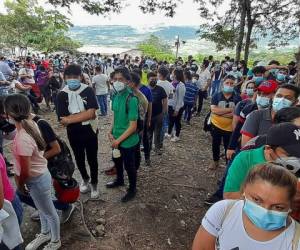 Hondureños y nicaragüenses hacen cola para vacunarse con las vacunas Pfizer-BioNTech y Moderna contra la enfermedad del nuevo coronavirus en Guasaule, Honduras, en la frontera entre los dos países, el 22 de octubre de 2021. Foto: AFP