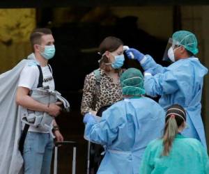 Personal sanitario toma la temperatura a una huésped del hotel H10 Costa Adeje Palace en La Caleta, en la isla canaria de Tenerife, España, el 28 de febrero de 2020. Foto: AP.