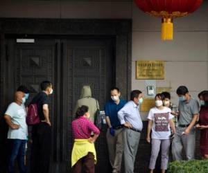 Decenas de personas acudieron este miércoles al consulado chino para realizar trámites y se encontraron con las puertas cerradas. Foto: AFP.