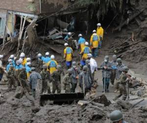 Miembros de las Autodefensas y policías buscan personas desaparecidas en el lugar de un deslizamiento de tierra luego de días de fuertes lluvias en Atami, en la prefectura de Shizuoka, el 5 de julio de 2021. Foto: AFP