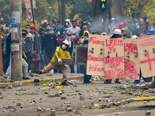 Los manifestantes están en lo alto de una barricada durante el décimo día de una protesta por un aumento en el precio del combustible ordenado por el gobierno para asegurar un préstamo del FMI, en los alrededores de la Asamblea Nacional en Quito.