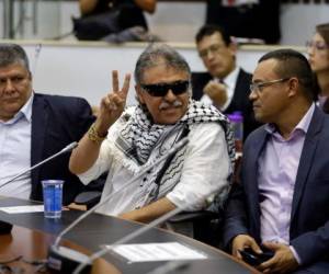 El ex rebelde de las FARC, el legislador Jesús Santrich, hace la se al de la victoria a periodistas durante una sesión de la cámara baja en Bogotá, el miércoles 12 de junio de 2019.