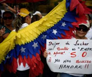 Una enfermera sostiene una pancarta durante una protesta por la falta de medicamentos, suministros médicos y malas condiciones en los hospitales, frente a la sede del Instituto Venezolano de Seguridad Social (IVSS) en Caracas, el 14 de agosto de 2019. Fotos: Agencia AFP.