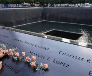 Un doliente reza por el recorte del nombre del fallecido Emilio Pete Ortiz en el Museo y Memorial Nacional del 11 de septiembre, el viernes 11 de septiembre de 2020, en Nueva York.