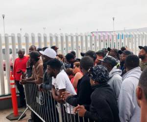 En esta fotografía del domingo 28 de julio de 2019, migrantes en Tijuana, muchos de Camerún, escuchan nombres anunciados en voz alta para los que pueden solicitar asilo en Estados Unidos ese día. Fotos: Agencia AP.